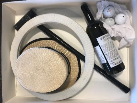 Archival objects from the Karl Carsony Papers, including Carsony’s boater hat, balancing cane, acrobat hoops, three golf balls, and a souvenir wine bottle.