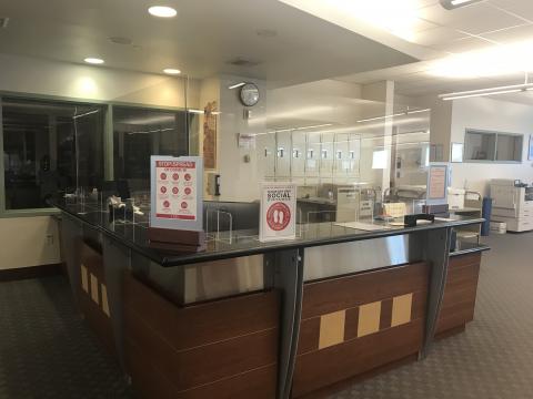 Special Collections & Archives reference desk with plexiglass shields and Covid prevention signs. 