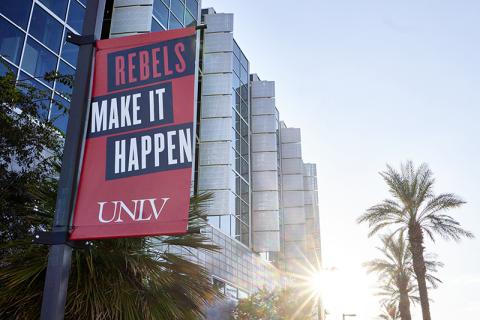 Exterior of Lied Library with Rebels Make It Happen banner hanging on a light pole