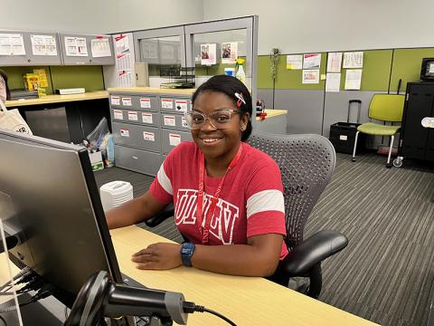 A student assistant working at a computer.