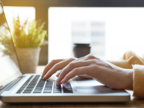 Hands typing on a laptop.