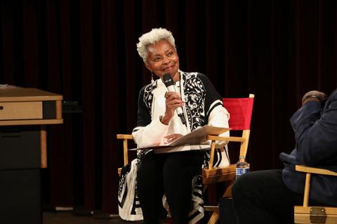 A woman speaks into a microphone.