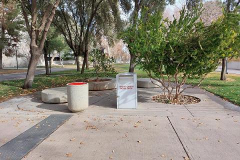 Medium white library drop box located on the sidewalk north of the Chemistry Building.