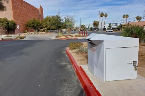 Large white library drop box located on the curb in parking lot B to the east of the Alta Ham Fine Arts building.