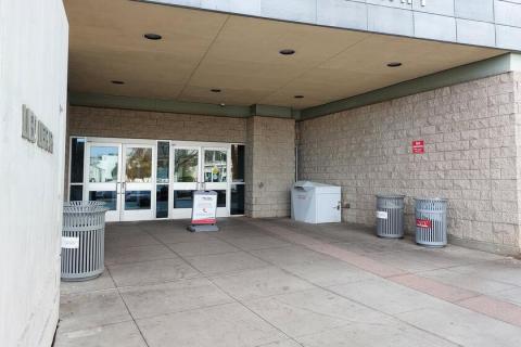 Large white library drop box near the north entrance to Lied Library facing Harmon Avenue.