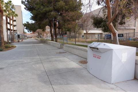 Large white drop box located near the southwest corner of the Cottage Grove Parking Garage.
