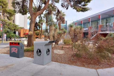 Medium gray library drop box near the northwest corner of the Student Union, just outside of Valerie Pida Plaza.