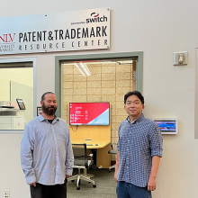 Patrick Griffis and Youngwoo Ban stand outside the UNLV Libraries Patent & Trademark Resource Center powered by Switch.