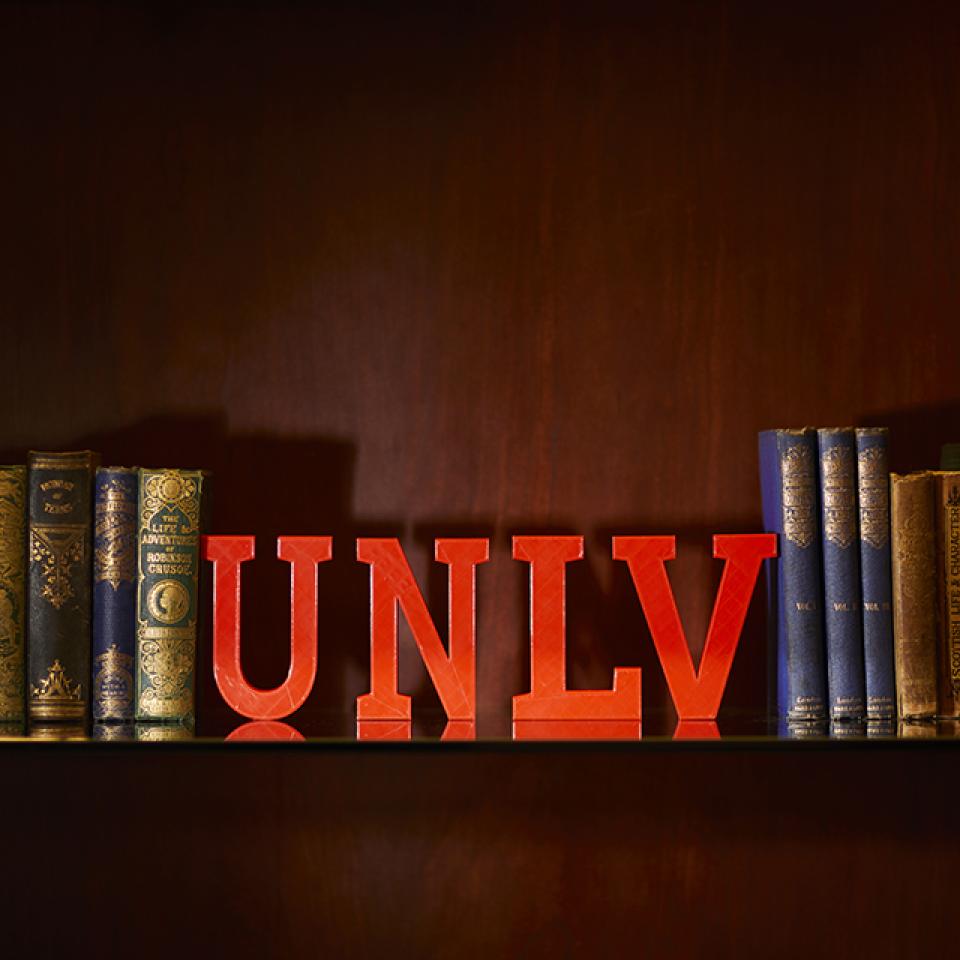 Shelf with vintage books and red "UNLV" letters.