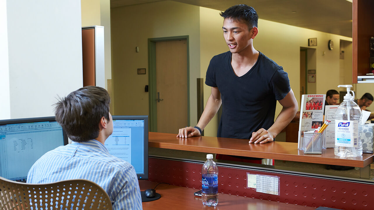 Student asking a question at the research assistance and computer help desk