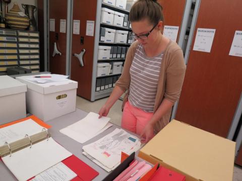 graduate student working with documents on a table