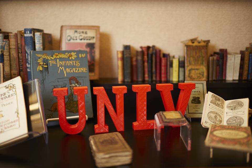 Display of vintage books with large red "UNLV" letters in front.