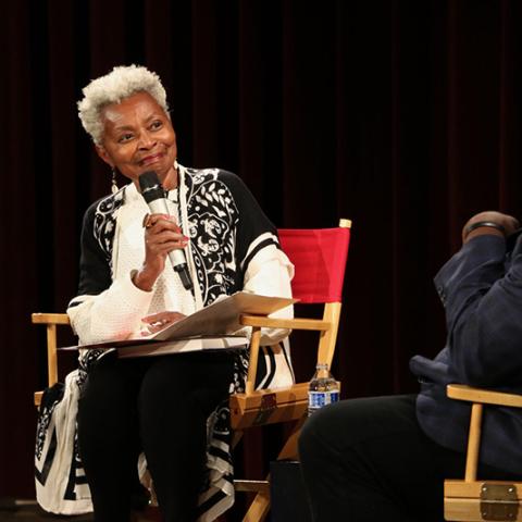 A woman speaks into a microphone.