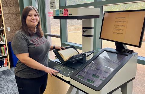 A student scans a book at the Music Library