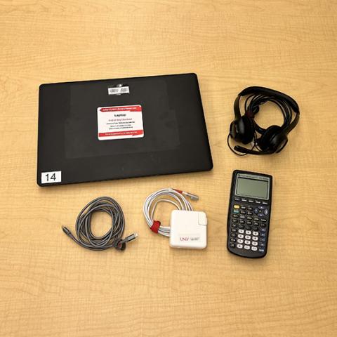 laptop, headphones, cords and a calculator on a table