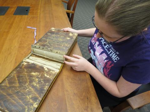 Kayla shows the detached binding from the photo album
