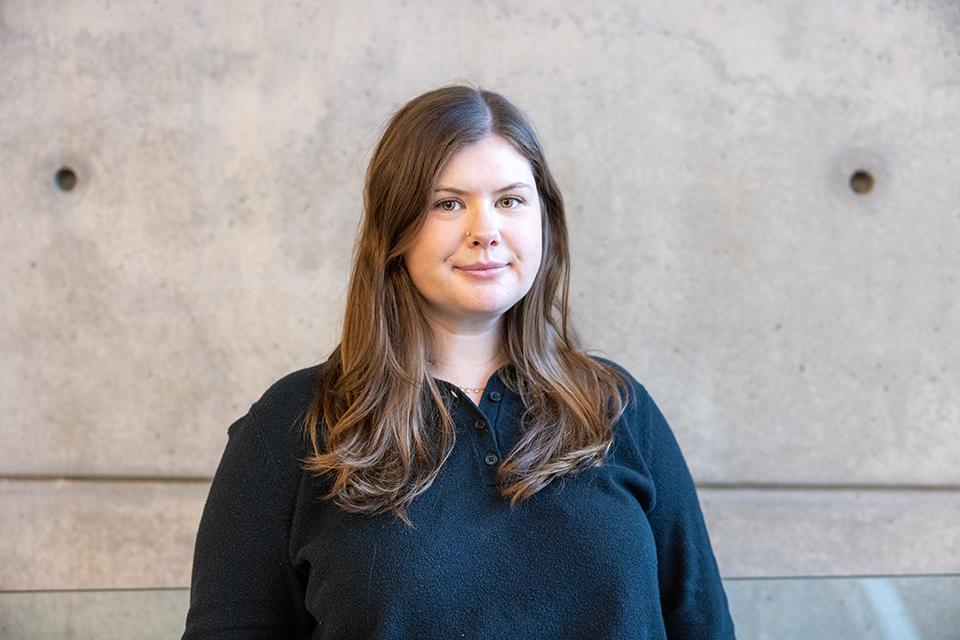 A person standing in front of a cement wall.