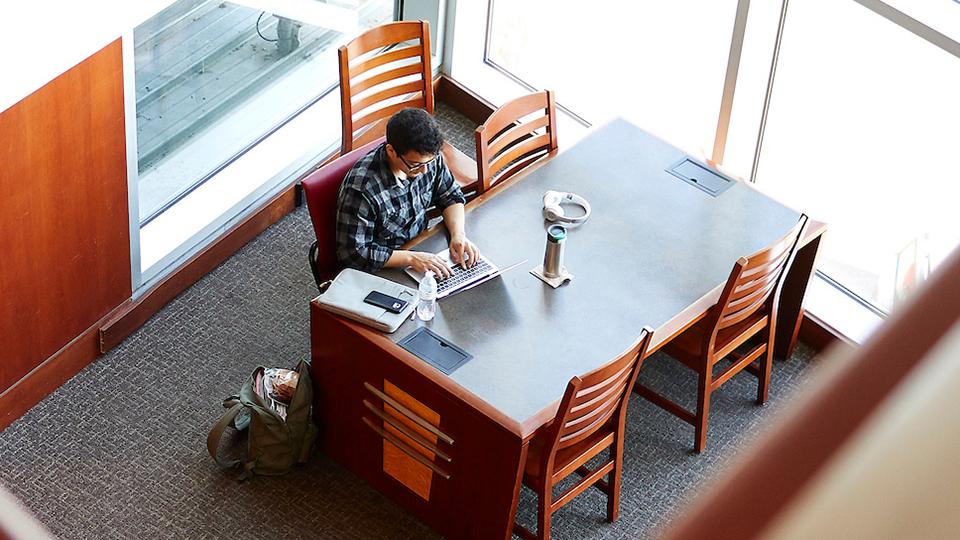 A student works on a project at a table in Lied Library.