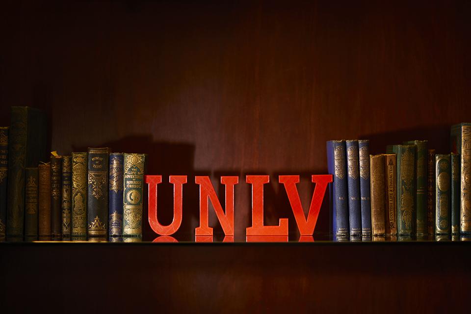 Shelf with vintage books and red "UNLV" letters.