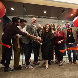 A group of people cut the ribbon opening the new Dreamscape Learn center in Lied Library.