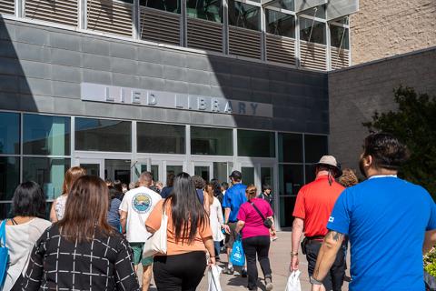 A group of people approaches the entrance of Lied Library, with a sign overhead.