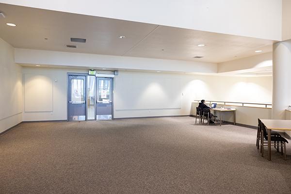 Smaller second floor library event space with white walls and carpeted floor.