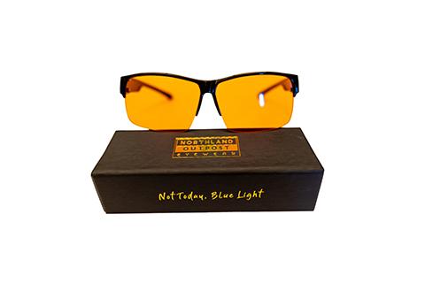 Blue light blocking glasses with orange lenses, displayed on a black case labeled ‘Northland Outpost Eyewear’ and ‘Not Today, Blue Light.