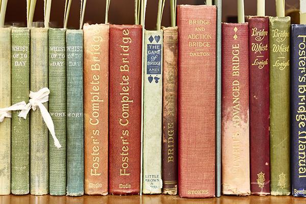 A row of historical hardcover books about gaming with colorful spines on a shelf.