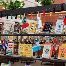 Library display featuring Latinx literature with various books and small flags.