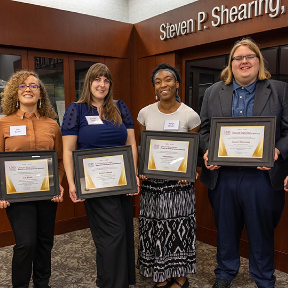 Six people holding award certificates.