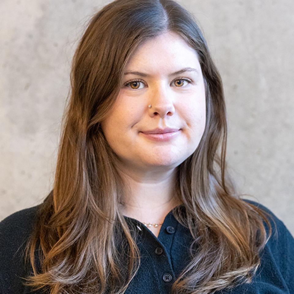 A person standing in front of a cement wall.