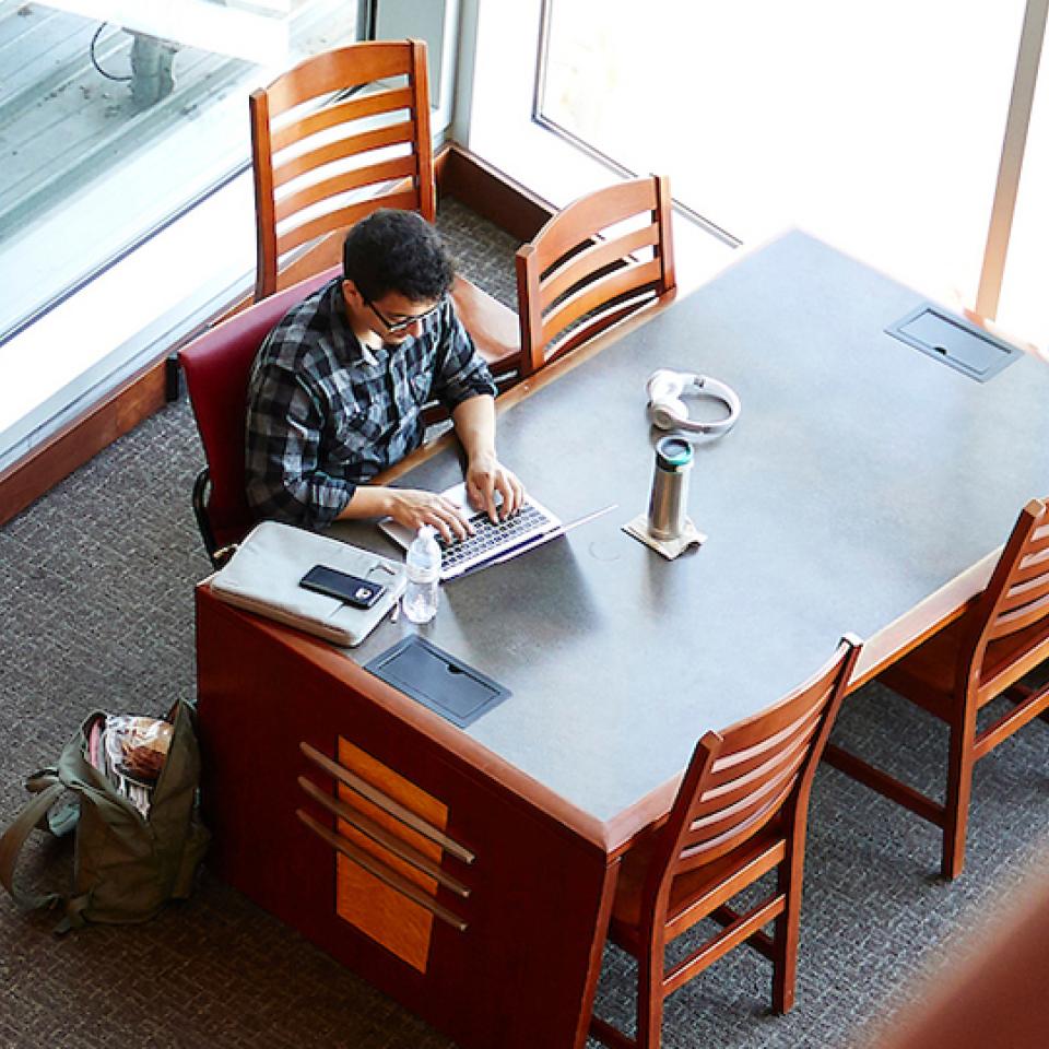 A student works on a project at a table in Lied Library.