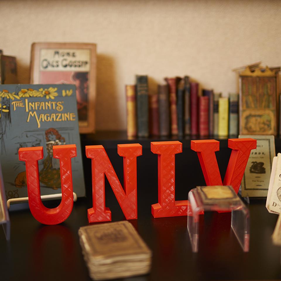 Display of vintage books with large red "UNLV" letters in front.
