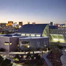 Aerial view of Lied Library at dusk, with the Las Vegas city skyline in the background.