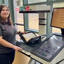 A student scans a book at the Music Library