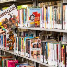 A hand pulls a book off a bookshelf. 