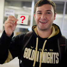 A UNLV student holding a sticker.