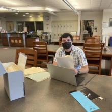 Peter Gresma sitting at table with archival research materials