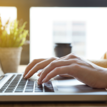 Person typing on laptop keyboard