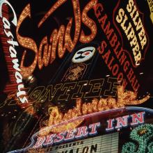 A collage of historic neon signs from Las Vegas casinos, featuring "Sands," "Silver Slipper," "Frontier," "Castaways," "Landmark," and "Desert Inn".